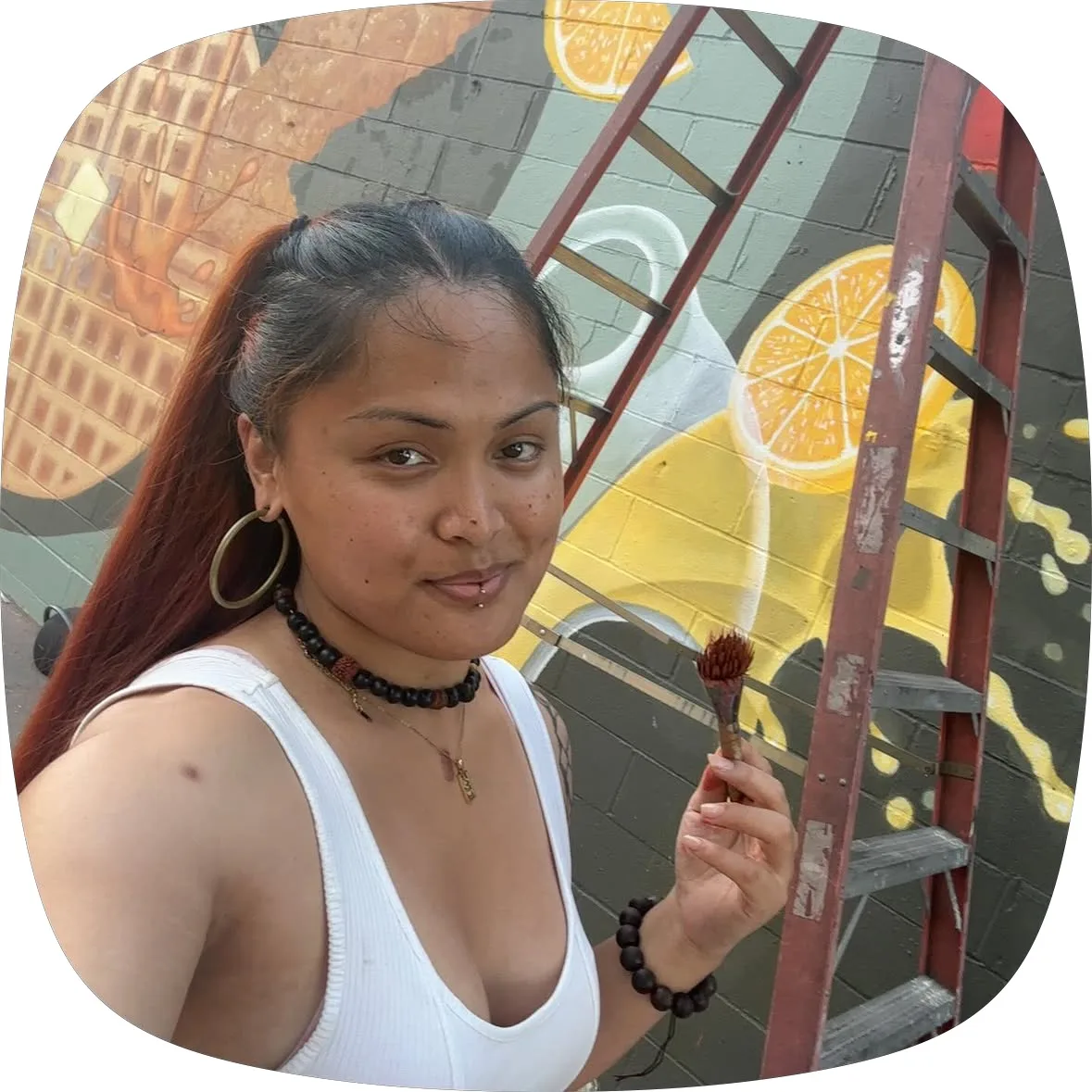 Jenesis J. Diwa painting her mural in Sacramento